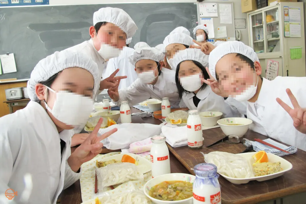 Japanese elementary school students in their white school lunch uniform.