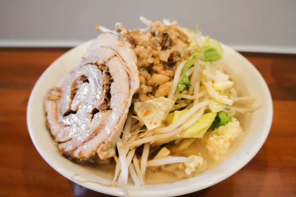 A bowl of ramen at Ramen-sou Yamaroku in Onagawa piled high with thick noodles, garlic, roast pork and pork fat.