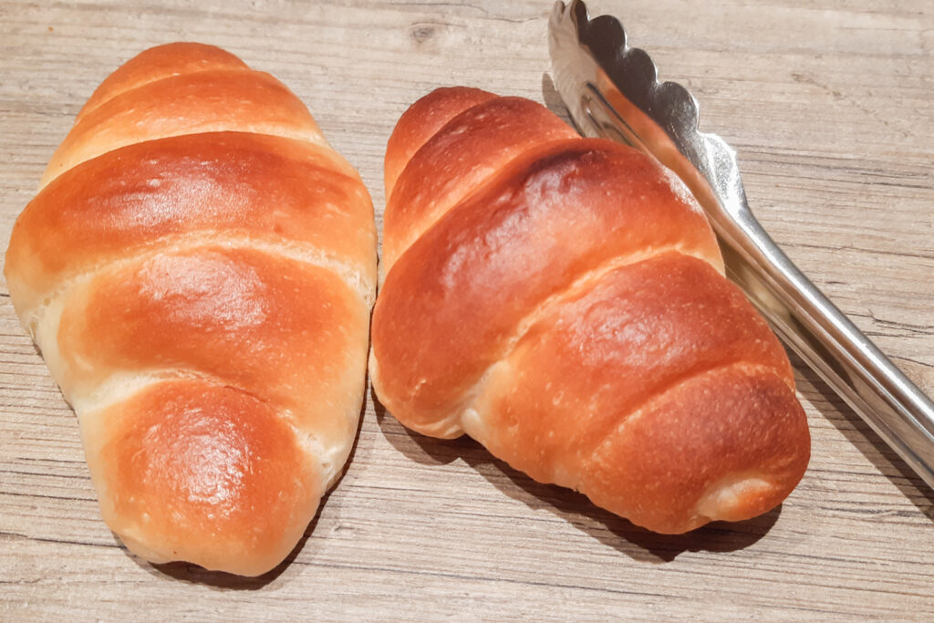 Wasei Eigo: Pictured is a pair of metal tongs and two "butter rolls" - a small dinner roll type bread product with similar lined markings as a crescent roll.