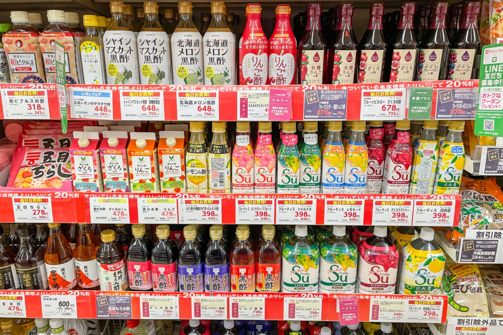 A section of a Japanese supermarket filled top to bottom with vinegar products, mostly drinks.