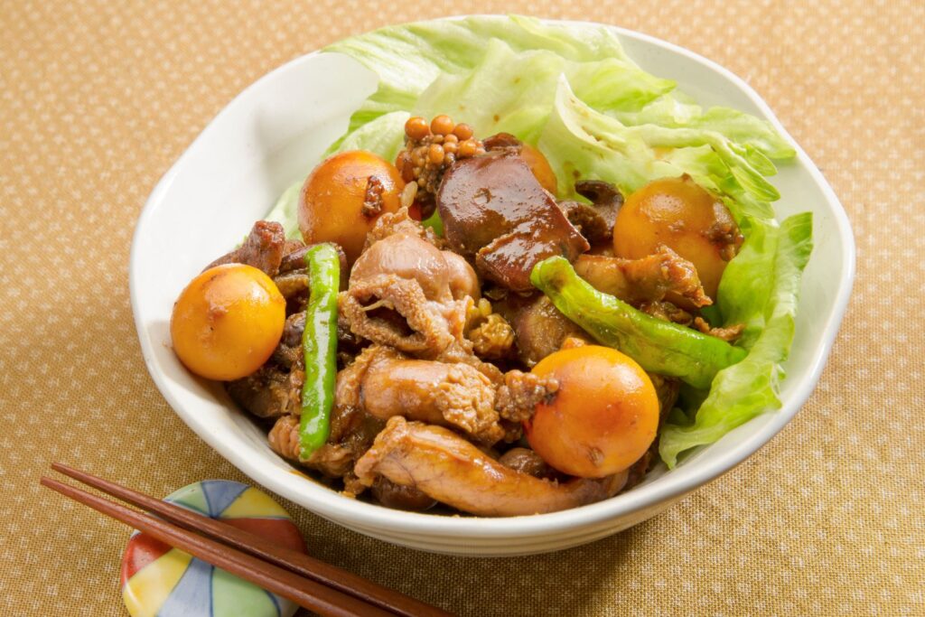 Yamanashi food: A bowl of boiled and marinated Kofu chicken offal. There is some lettuce tucked into the side of the bowl and amongst the chicken offal are the bulbous yellow sacks containing the immature hen's eggs.