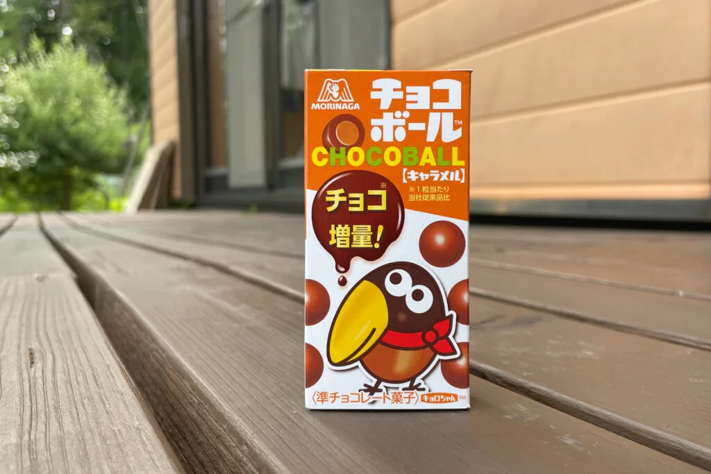 A box of Morinaga Chocoballs. The design is mostly orange, brown and white in color and has a cartoonish image of a parrot.
