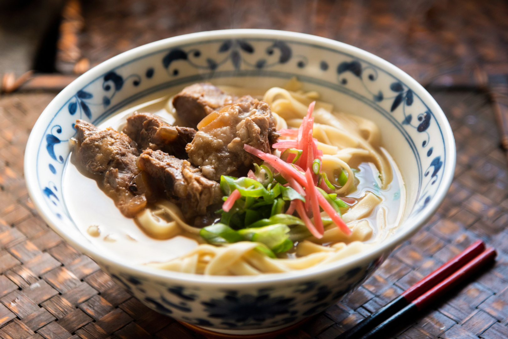 Okinawa food: A bowl of Okinawan noodles topped with pork, pickled ginger and green onions.
